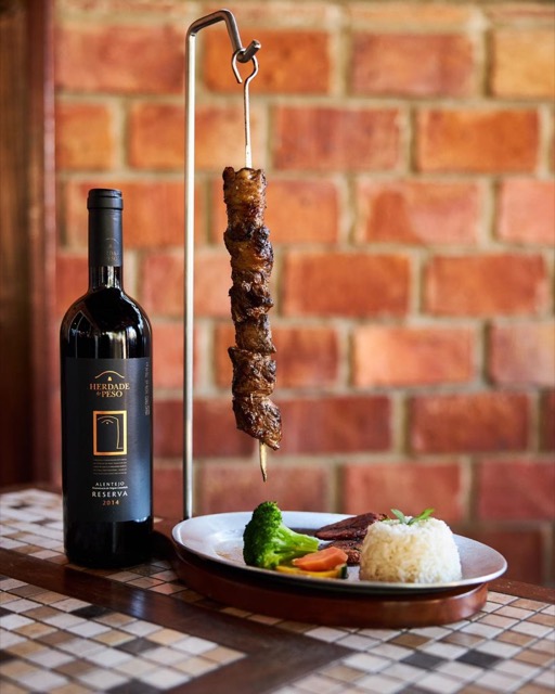 A plated dish and a bottle of wine at Gostoso