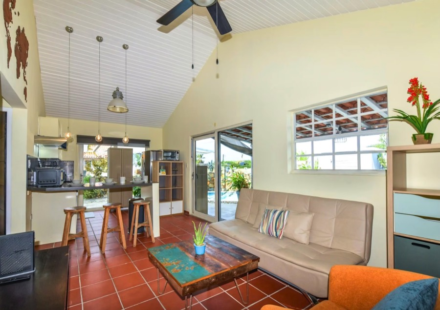 Living room with vaulted ceiling, sofa, and tiled floor