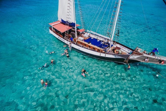 A catamaran anchored over clear turquoise water