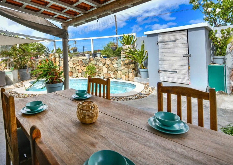Outdoor dining table on the covered patio beside the pool