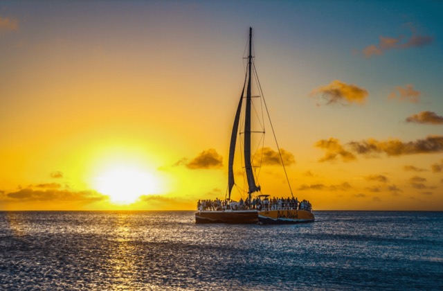 A sailboat silhouetted against the setting sun